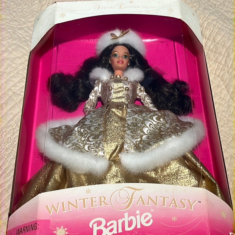 Barbie is a brunette in a gold winter gown trimmed in white fur.